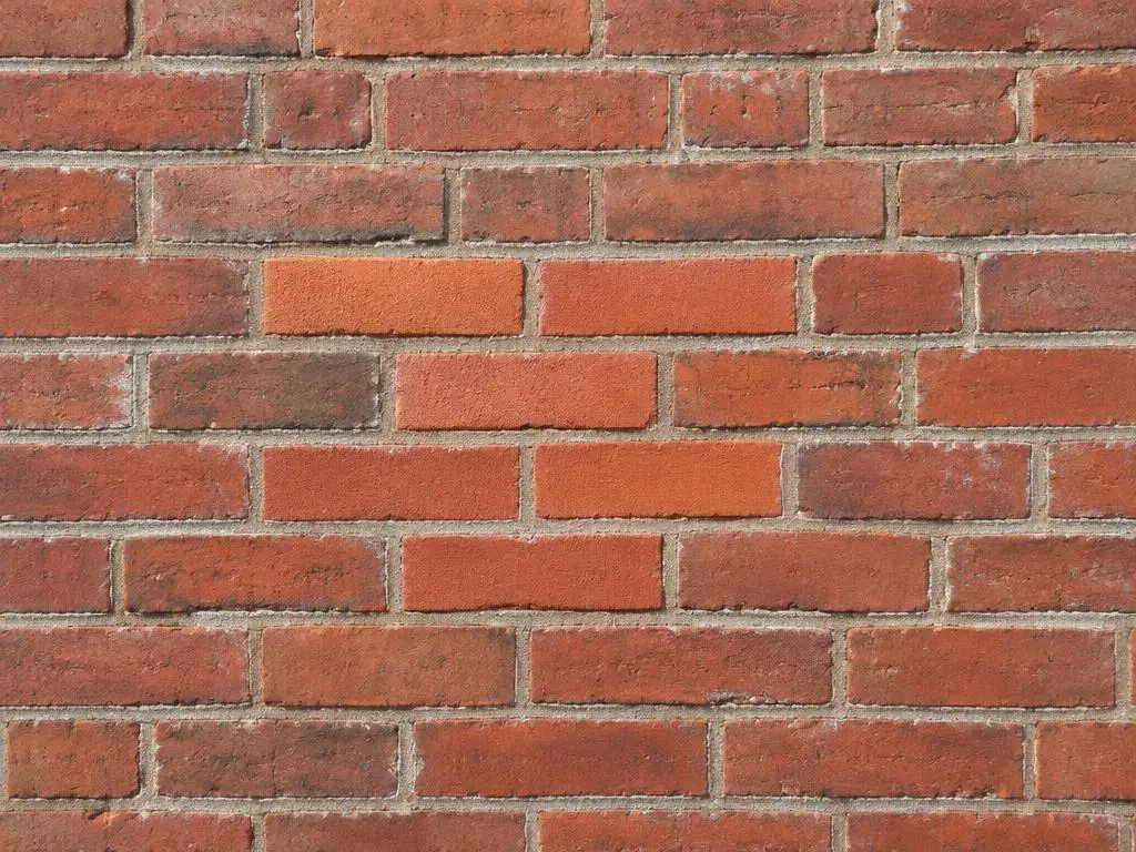 Brick Repairs in Yorkshire Red brick wall with several newly replaced bricks blended into the original brickwork
